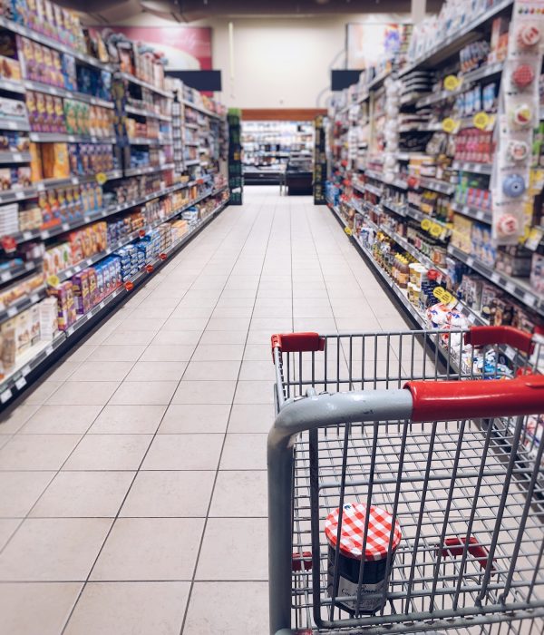 Grocery cart in the middle of a grocery store aisle